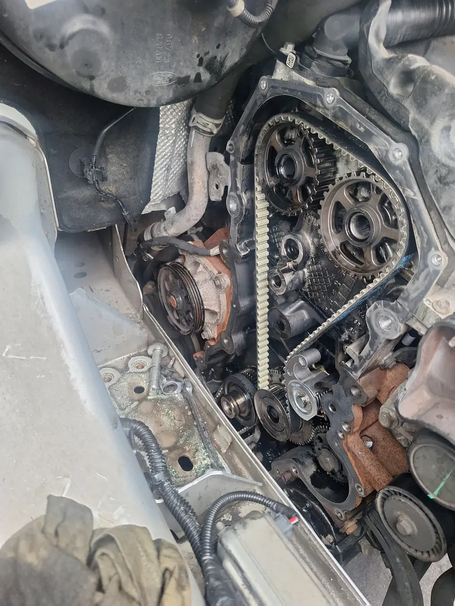 An engine with the timing cover off, showing the belt, sprockets and water pump